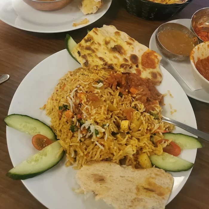  Biryanis with bread, and salad on a plate served at Kathmandu Restaurant Glasgow 