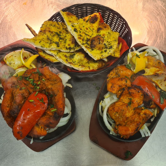  two Chicken Tikkas on a plate with bread served at Kathmandu 
Restaurant Glasgow 